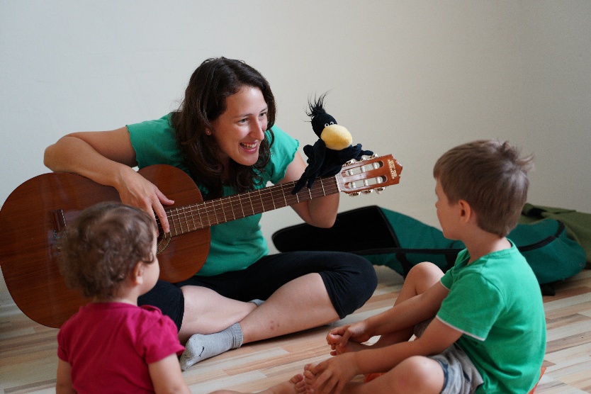 Johanna musiziert mit Kindern und einer Frosch-Handpuppe