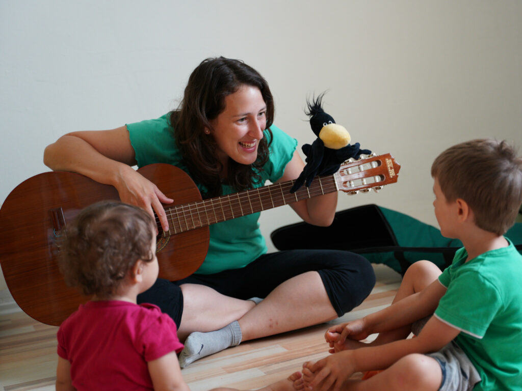 A young boy holding a guitar